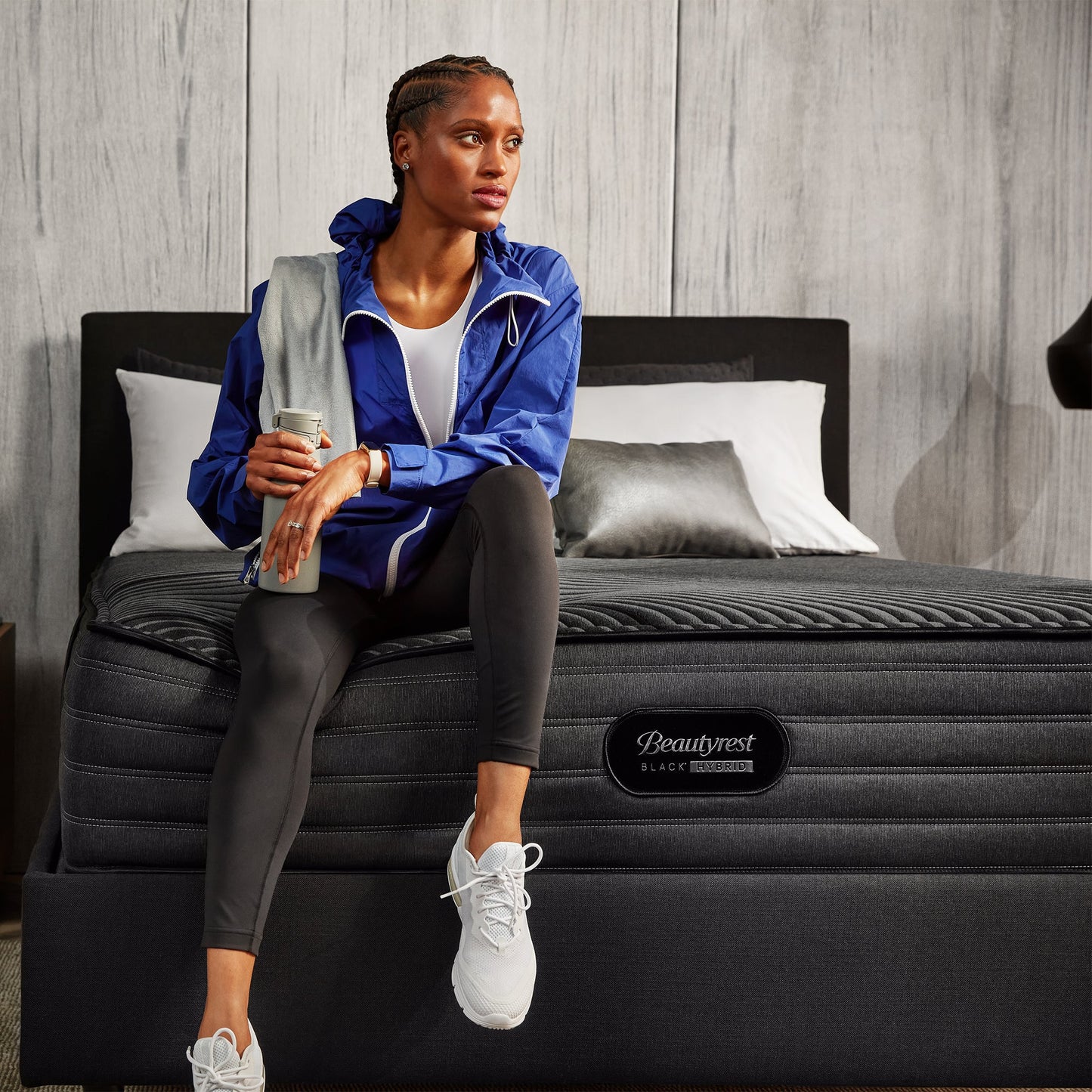 Woman With A Water Bottle And Sportswear Sitting On The Edge Of A Beautyrest Black Hybrid L-Class Firm Mattress