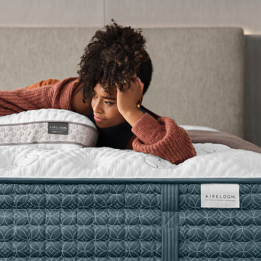 Woman Relaxing On An Aireloom Sonata Plush Mattress In A Bedroom