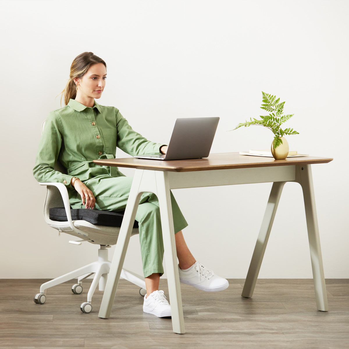 Woman Sitting On The Purple Double Seat Cushion On An Office Chair And Working On A Laptop At An Office Desk