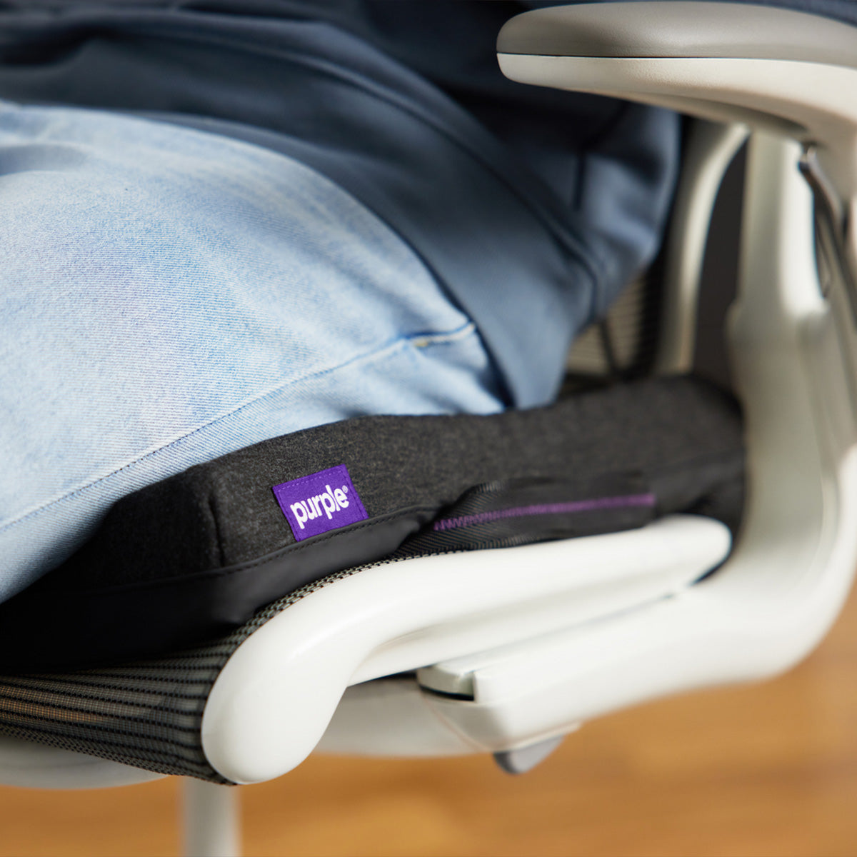Person Sitting On The Purple Double Seat Cushion That Is Placed On An Office Chair