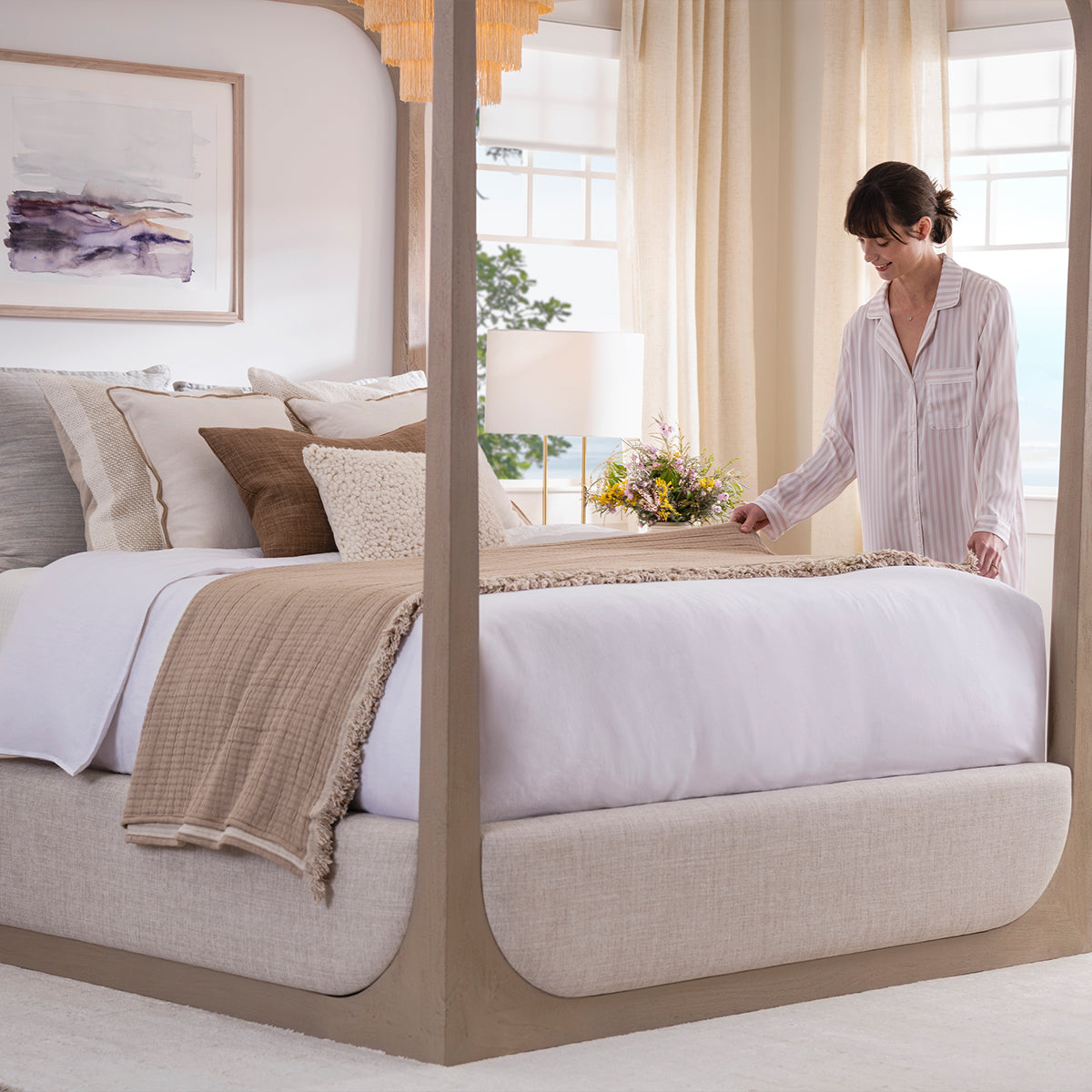 Woman putting blankets on Purple Restore Premier Firm Mattress