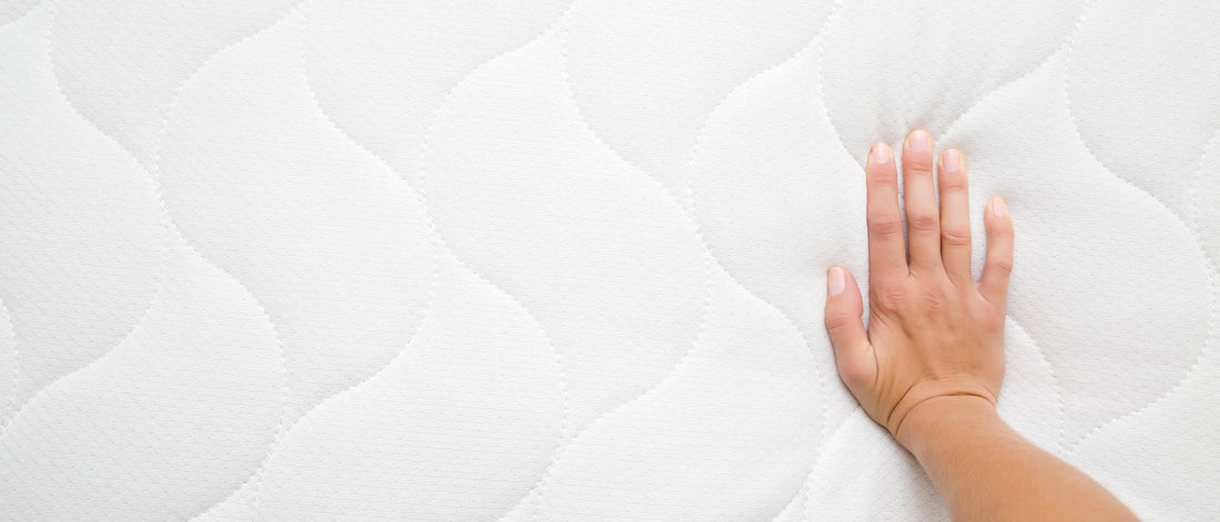 a woman feeling the firmness of a mattress