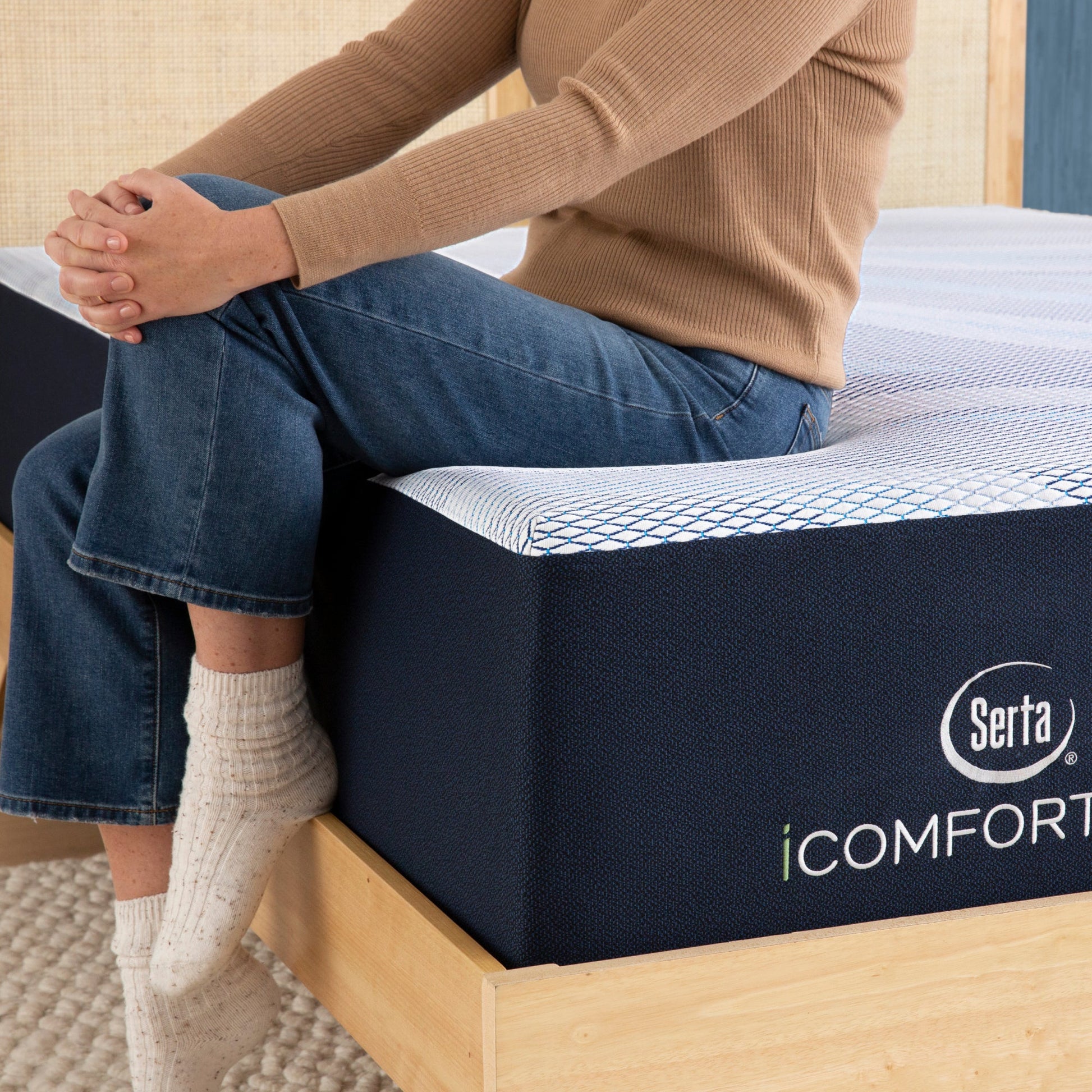 Person Sitting On Serta iComfortECO Enhanced Foam Firm Mattress
