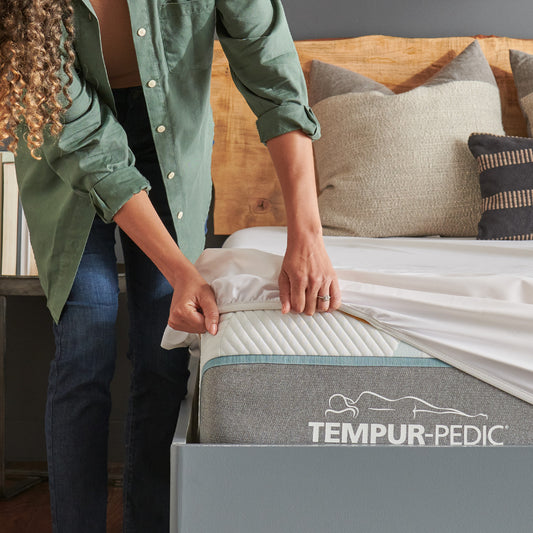 Model fitting Tempur-pedic TEMPUR-Breeze® Mattress Protector onto mattress.