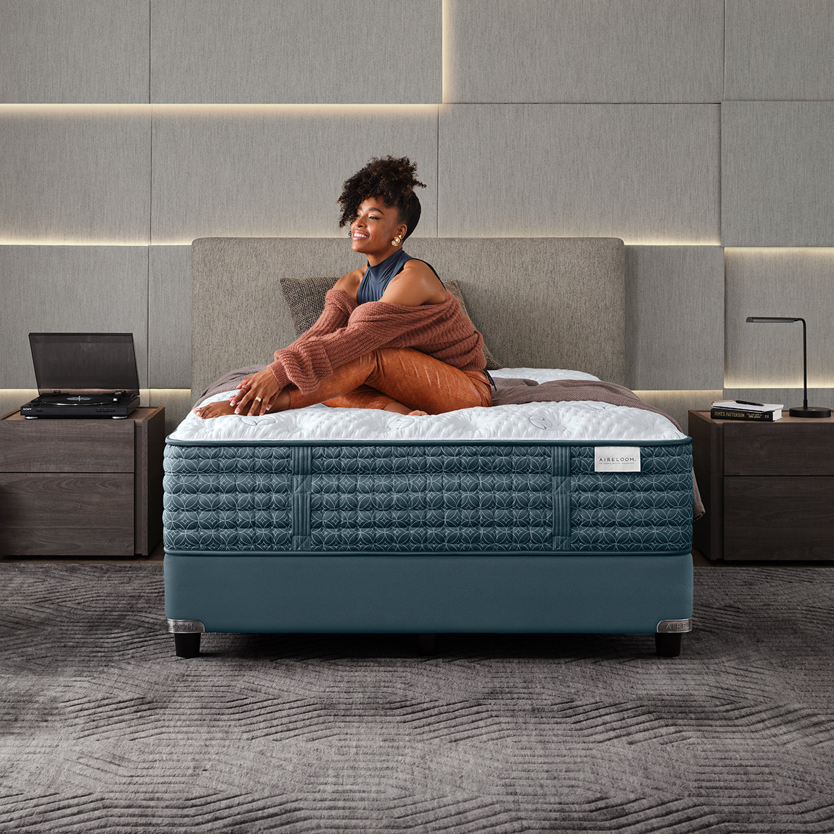 Woman Relaxing On An Aireloom Duet Luxury Firm Mattress In An Upscale Modern Minimalist Apartment Bedroom