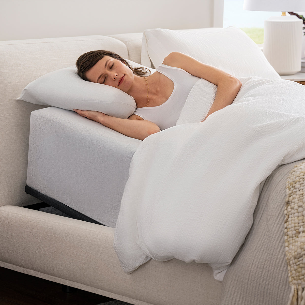 Woman sleeping on mattress elevated by Purple Premium Smart Adjustable Base