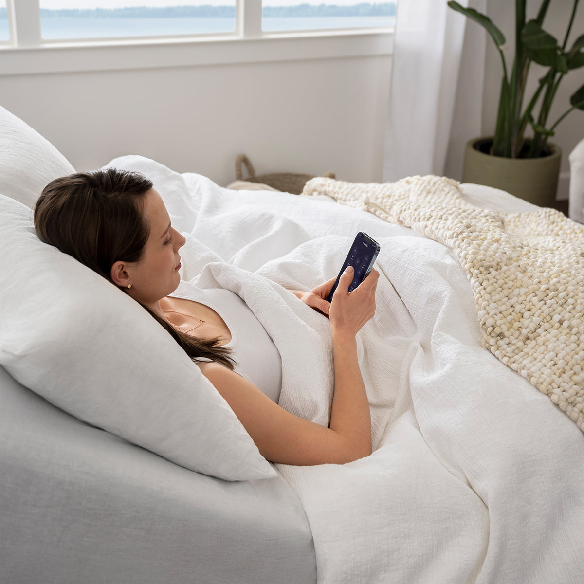 Woman reclined on mattress on a Purple Premium Smart Adjustable Base
