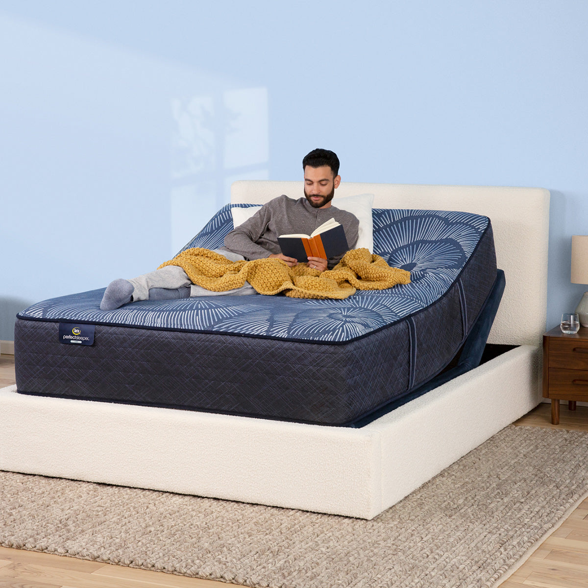 Man laying on mattress elevated by a Serta Motion Essentials Adjustable Base