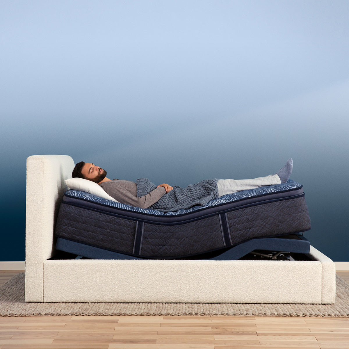 Man laying on mattress elevated by a Serta Motion Essentials Adjustable Base
