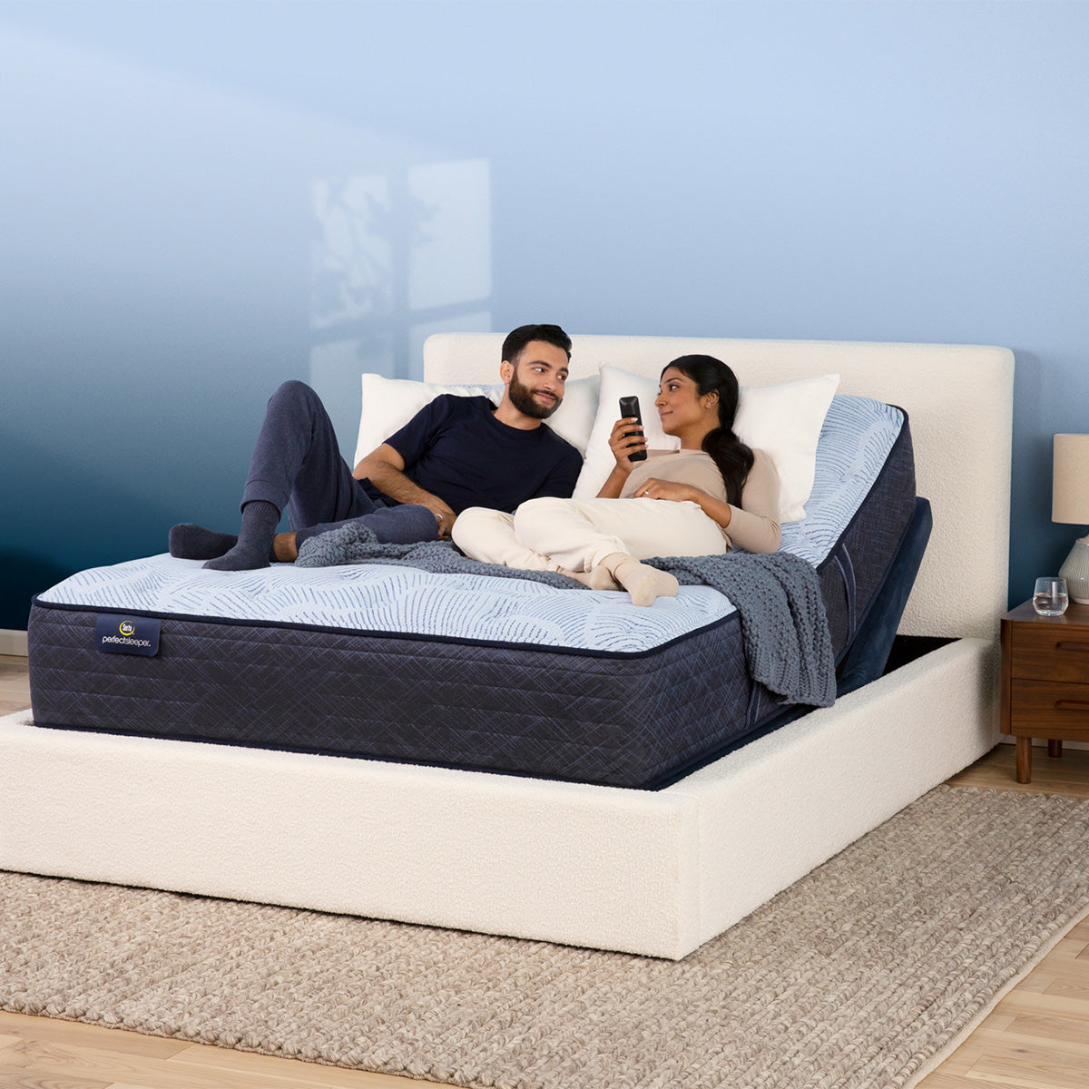 Couple playing on mattress elevated by a Serta Motion Essentials Adjustable Base
